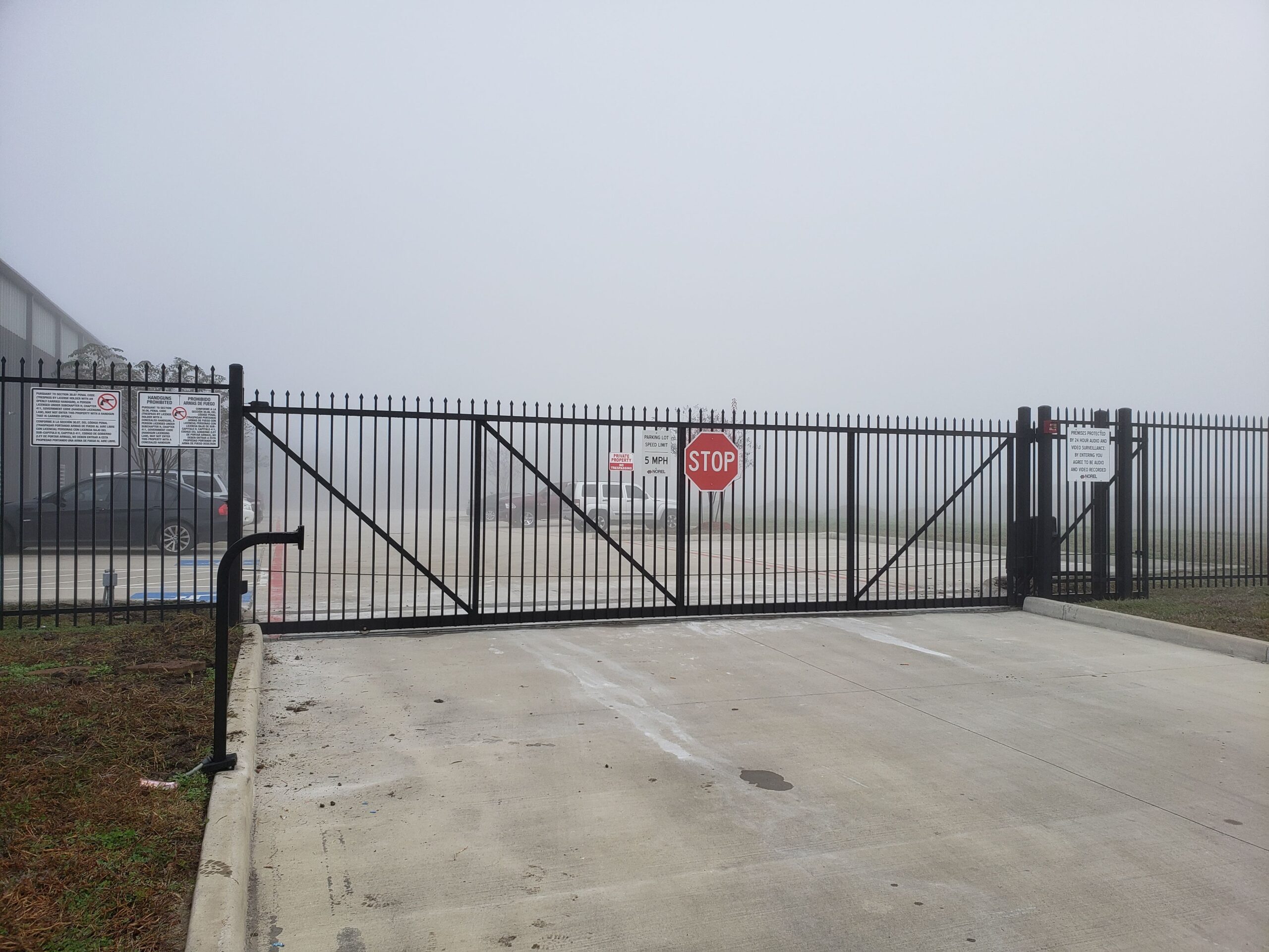Commercial double swing security gate with automatic opener at a Houston business entrance
