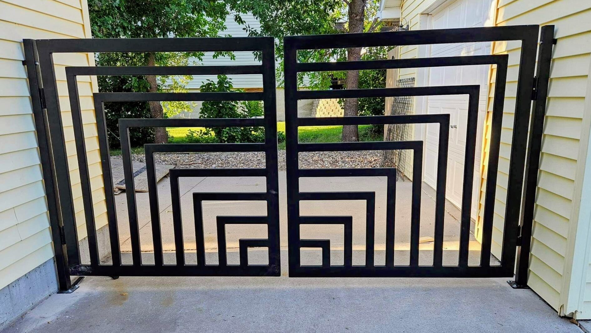 Custom modern wrought iron driveway gate installed for a West University TX property