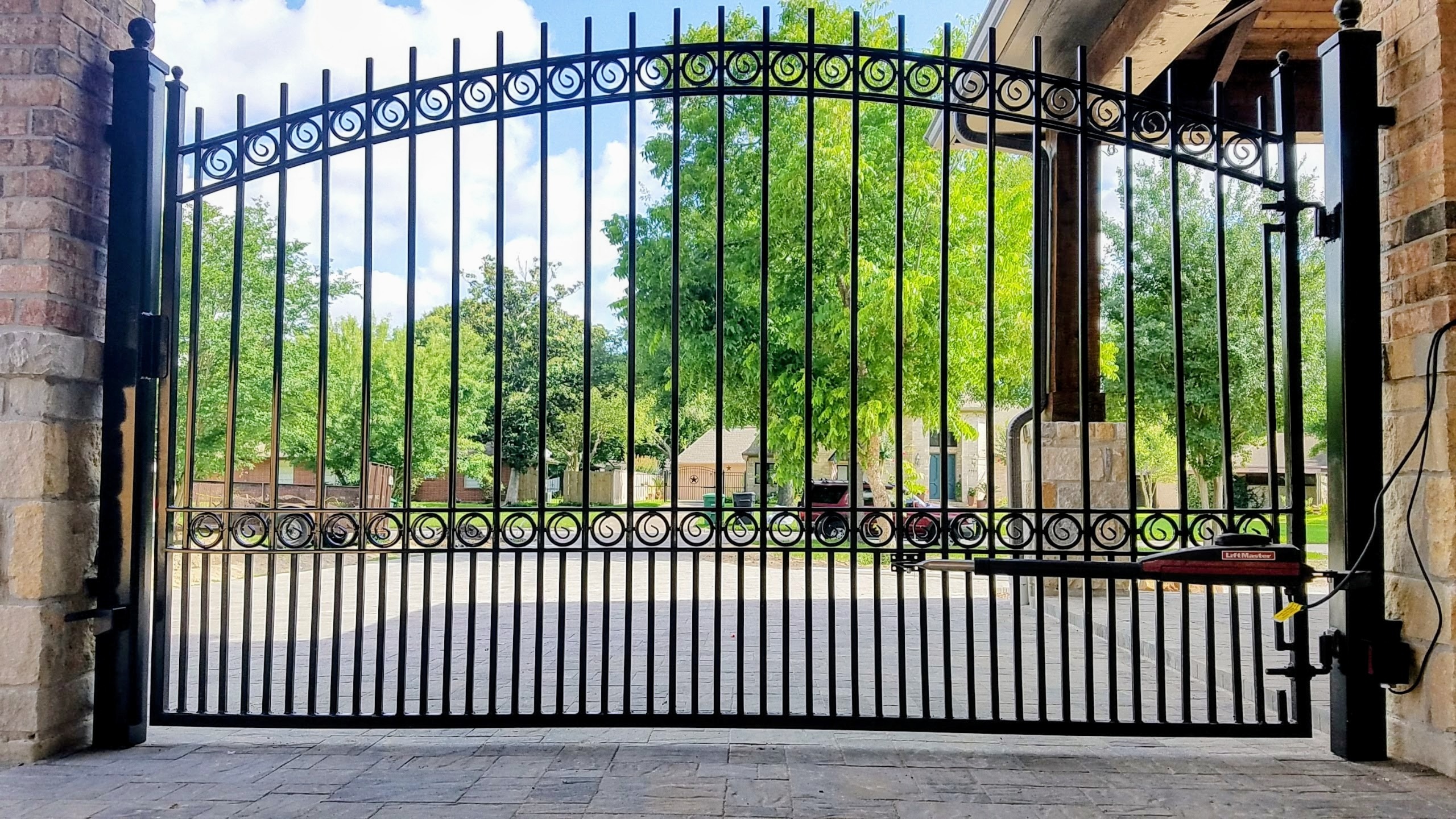 Decorative ornamental iron driveway gate with LiftMaster LA400 opener installed in Bellaire TX